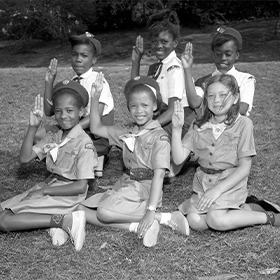 Local Girl Scout Juniors and Cadettes demonstrate the Girl Scout Sign, circa 1964.