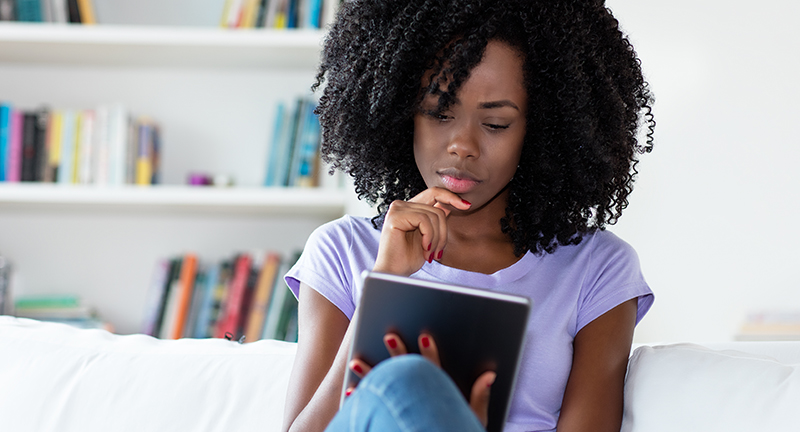 Woman reading on tablet in chair