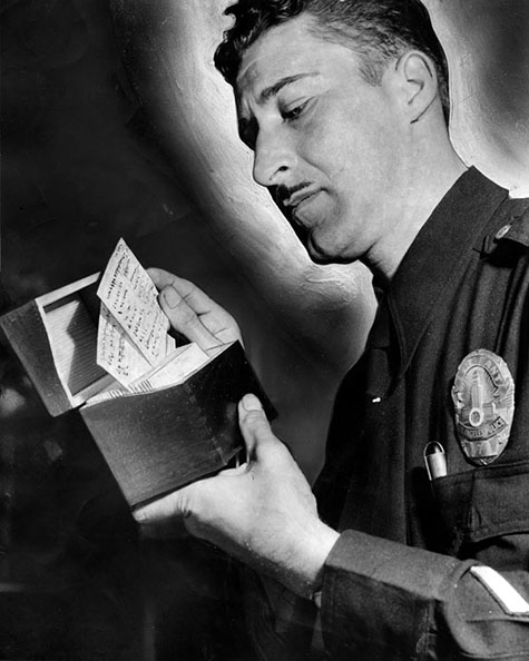 May 8, 1948 reads,Vice Sgt. C. W. Bates examines name-cards