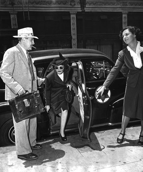 June 16, 1949 Brenda Allen wearing dark glasses, steps from an auto during a tour of deposit box vaults