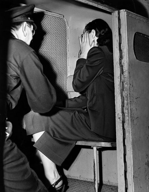 August 11, 1948 With her hand up, apparently to hide an ironically 'shamed' face, Brenda Allen sinks into corner of police patrol wagon