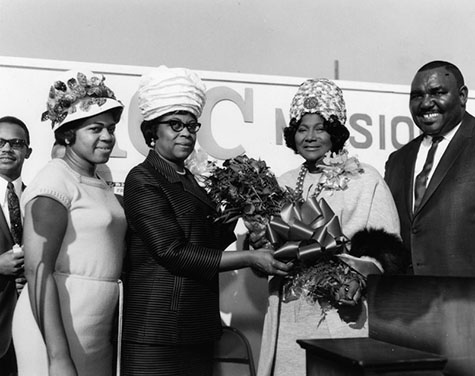 Gospel singer Mahalia Jackson has presented a bouquet of flowers as Rev. E. Boyd Ester looks on