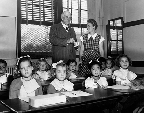 Dr. Alexander Stoddard, new superintendent of schools, and Mrs. Bertha Norton, teacher, look over the first group of children