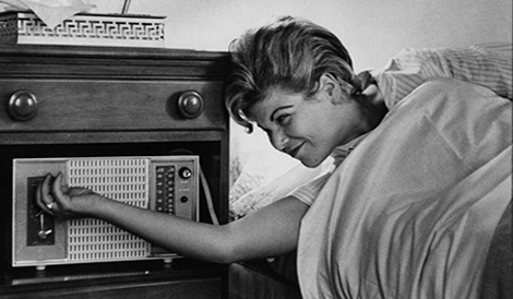 Women waking up and turning off her alarm clock