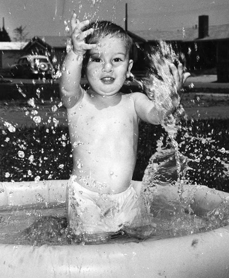 toddler splashing in pool