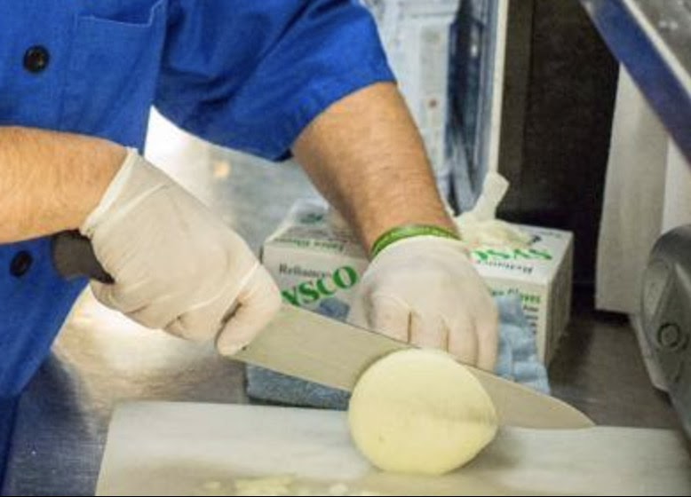man slicing something with gloves on