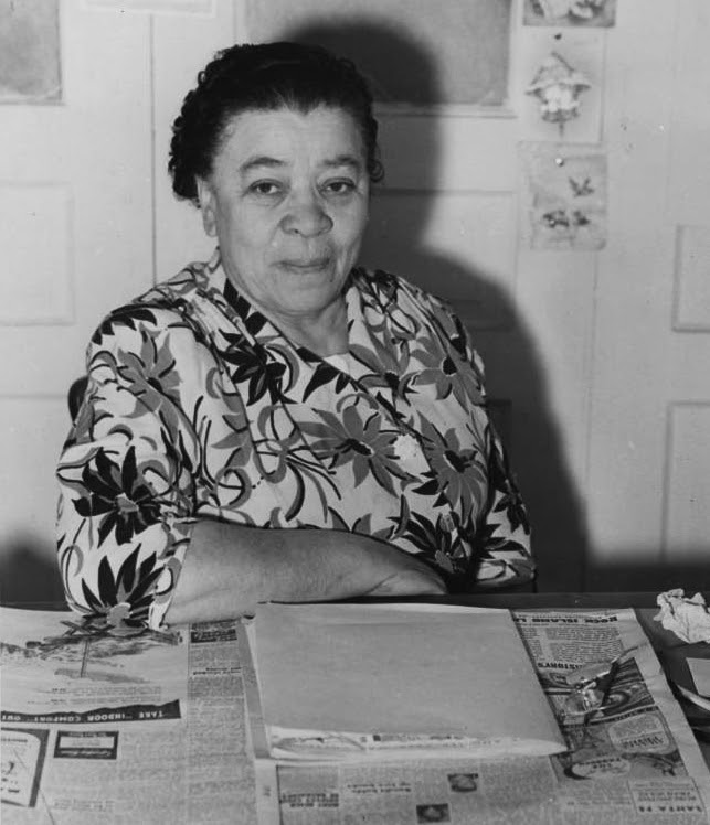 Charlotta Bass, seated at the editor’s desk of the California Eagle