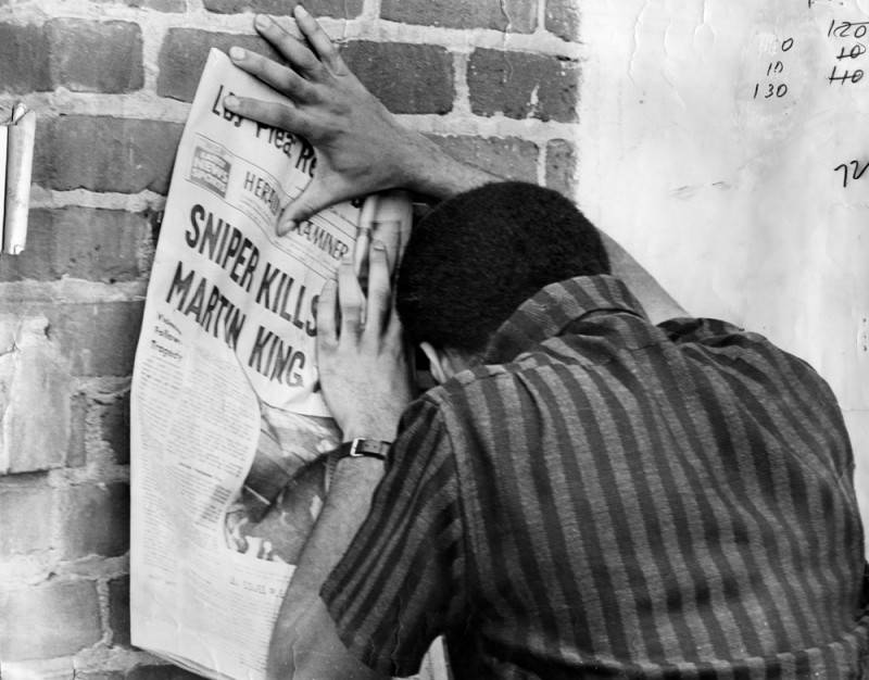 A Los Angeles resident collapses in grief while reading the details of Martin Luther King Jr.’s assassination