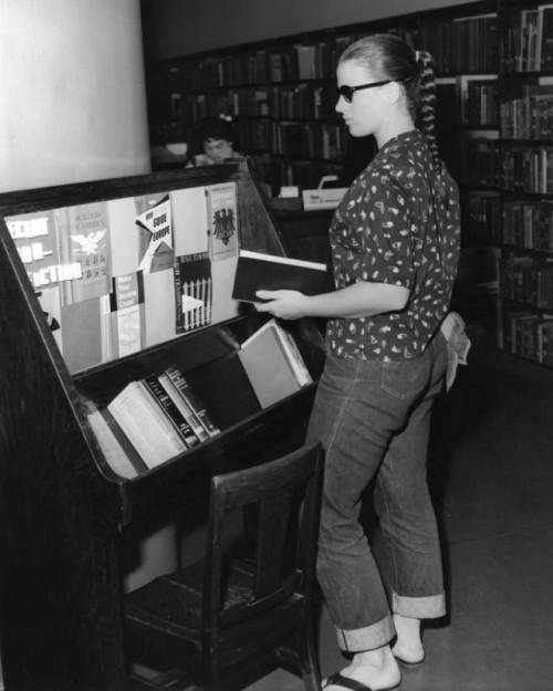 A young Hollywood Branch Library patron looking at the latest non-fiction books [1959] 