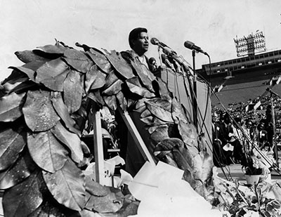 Cesar Chavez, standing next to a large wreath, pays tribute to the late Dr. Martin Luther King, Jr. 