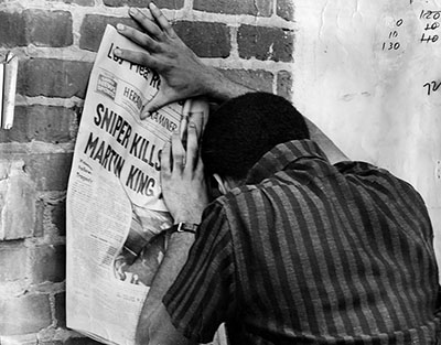 A Los Angeles resident collapses in grief while reading the details of Martin Luther King Jr.’s assassination. 