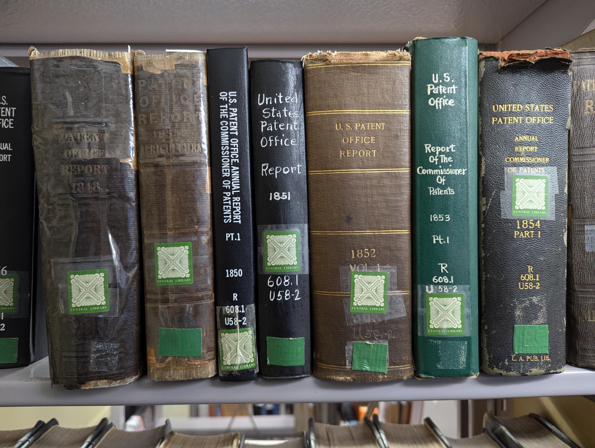 historic reference books on the subject of patents fill a book shelf