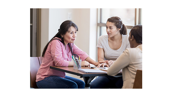 a mother and daughter consulting with an advisor across the table