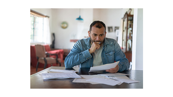 man sitting at a table looking at paperwork